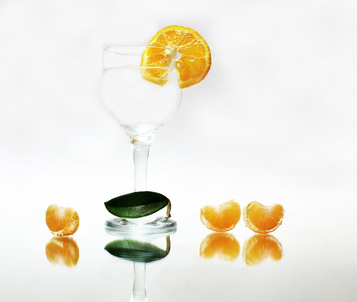 Апельсин в стакане с водой. Апельсин на бокале. Мандаринки с бокалом. Апельсин в фужере. Бокал шампанского и апельсины