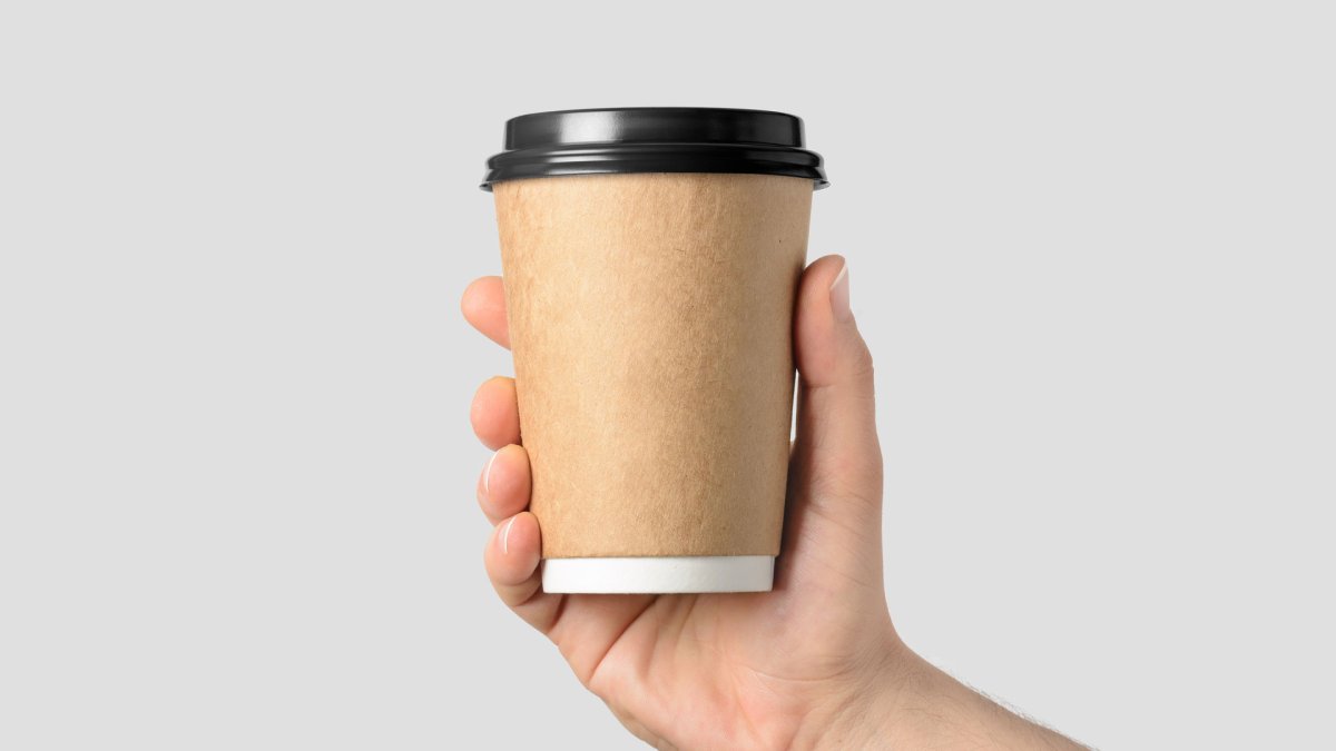 Белый стакан кофе в руке